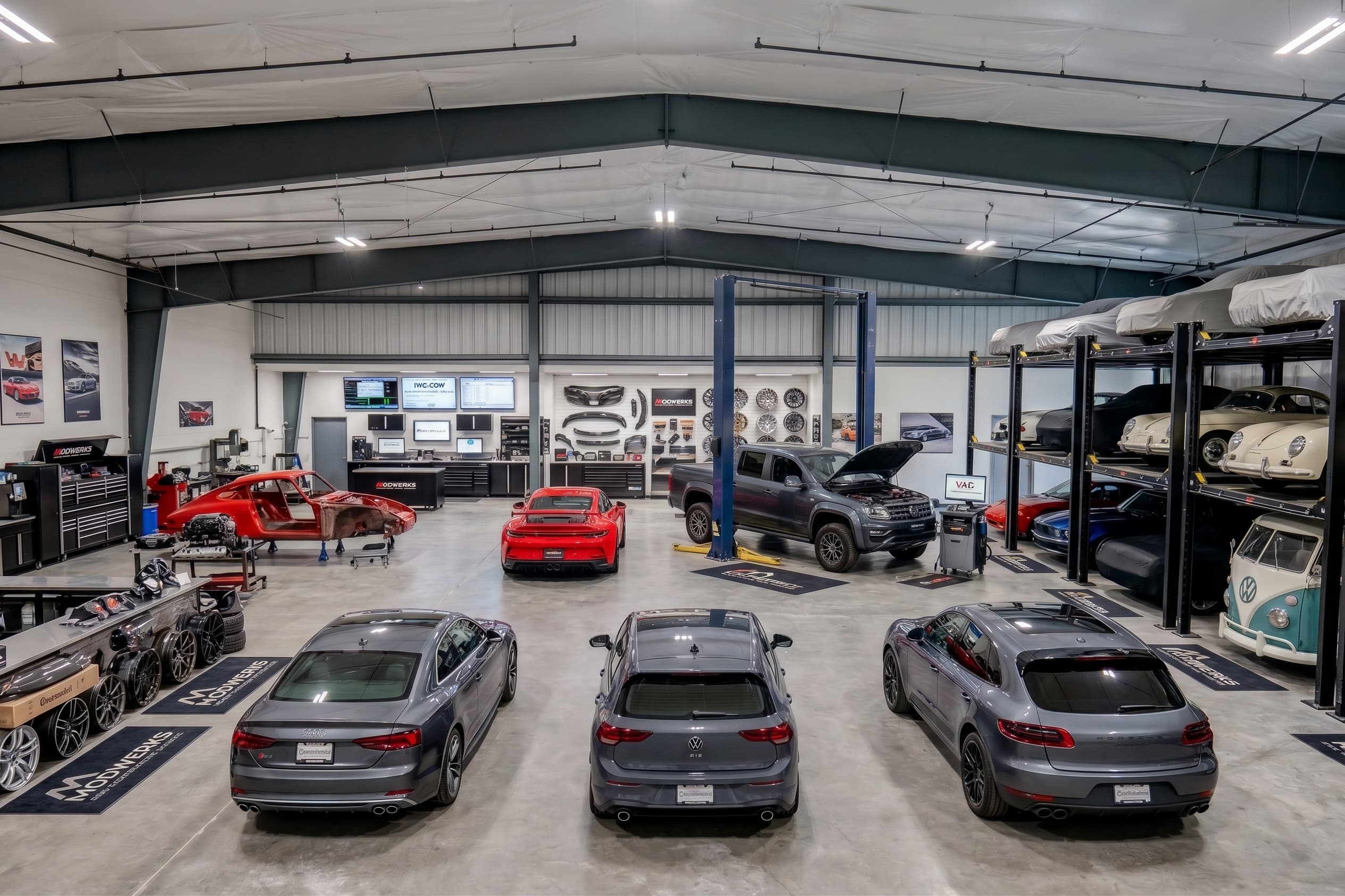 The ModWerks shop floor: vehicles on lifts, diagnostic equipment, and a wall of wheels and parts